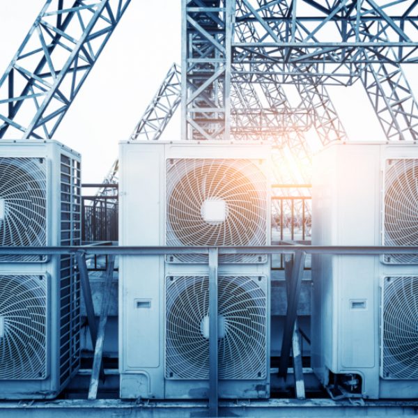 Air conditioner units (HVAC) on a roof of industrial building with blue sky and clouds in the background. Air conditioner units (HVAC) on a roof of industrial building with blue sky and clouds in the background.